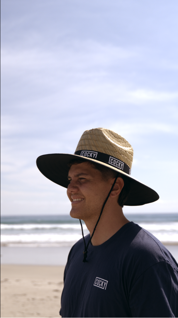 Person wearing a wide-brimmed hat on a beach